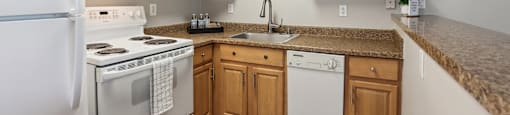 a kitchen with white appliances and wooden cabinets