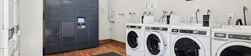 a washer and dryer room with laundry machines and a door to a bathroom