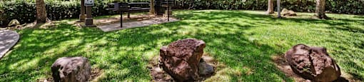 a backyard with a picnic area and rocks