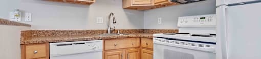 a kitchen with white appliances and wooden cabinets