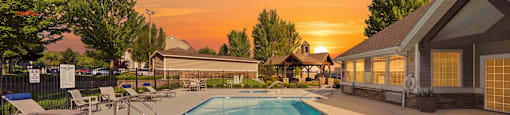 A large swimming pool with a sunset in the background.