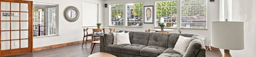 A living room with a grey couch and a wooden coffee table.