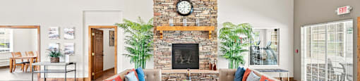 A living room with a stone fireplace and a couch.