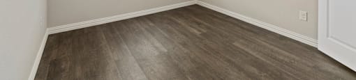 Two-Bedroom Rental Homes in Lewisville, TX - The Villas at Rockbrook - Bedroom with Wood-Style Hard Surface Flooring and Window.