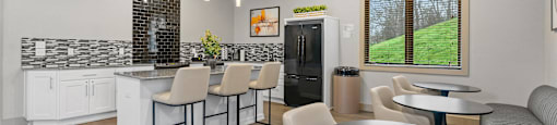A modern kitchen with a bar area and a dining table.