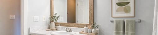 A bathroom with a white toilet, sink, and cabinets.
