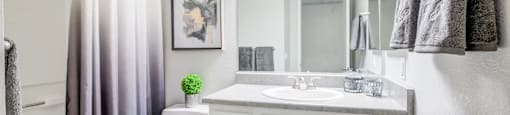 One Bedroom Senior Apartments in Paradise Las Vegas NV | Gramercy Parc | Bathroom Featuring Large Mirror and White Cabinetry