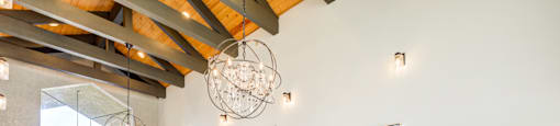 A large room with a wooden floor and a chandelier hanging from the ceiling.