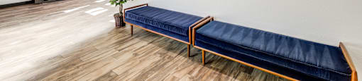 A room with a blue couch and a painting on the wall.