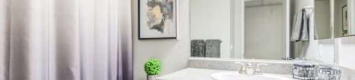 One Bedroom Senior Apartments in Paradise Las Vegas NV | Gramercy Parc | Bathroom Featuring Large Mirror and White Cabinetry