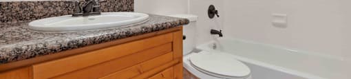 Dog-Friendly Apartments in Santa Clara, CA - Hidden Lake - Bathroom with Shower and Bathtub Combo with White Tile, Vanity with Wood-Style Cabinets and Granite Countertop.