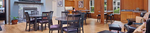 2-Bedroom Apartments in Santa Clara, CA - Hidden Lake - Resident Clubhouse With Wood Beam Ceiling, Dining Tables, Fireplace, Lounge Seating, And Kitchenette.