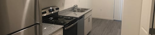 Apartments For Rent in Downtown Phoenix, AZ - VB on 12th Street - Kitchen with Wood-style Flooring, White Cabinetry, Stainless Steel Appliances, and Grey-Granite Countertops