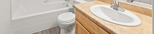 A white bathroom with a toilet, sink, and shower.