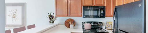 a kitchen with black appliances and wooden cabinets