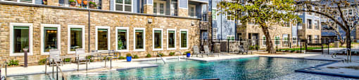 a swimming pool in front of an apartment building at LIV at Boerne Hills an Active Senior Community 62+, Texas, 78006