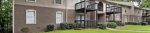Exterior of apartment building at Mirador at Idlewood in Clarkston, Georgia, featuring a well-maintained fresh green lawn and landscaped surroundings.