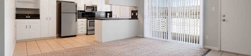Dog-Friendly Apartments in Gilroy, CA - Mission Park - Open-Concept Living Room with Carpeted Flooring, Floor-to-Ceiling Windows with Vertical Blinds, and View of Kitchen.