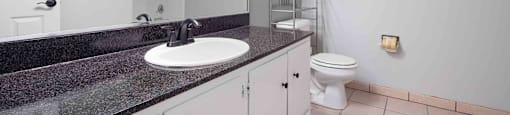 Gilroy, CA Apartments - Mission Park - Bathroom With Tiled Flooring, Toilet, Large Vanity Mirror, Wide Countertop, And A Shower