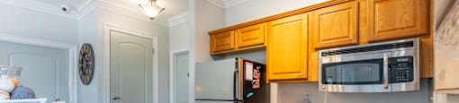 A kitchen with wooden cabinets and a black fridge.