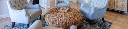 A living room with a ceiling fan and a wicker table.