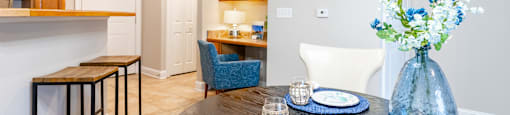 A dining table set with blue plates and a vase of flowers.
