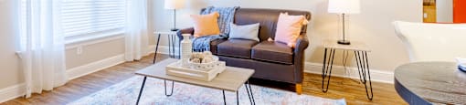 A living room with a couch, a coffee table, and a ceiling fan.