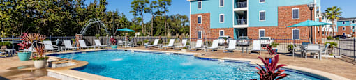 A pool surrounded by chairs and a building in the background.