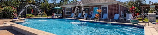 A pool with a slide and a house in the background.
