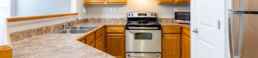 A kitchen with wooden cabinets and stainless steel appliances.
