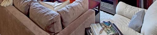 1-Bedroom Apartments in Portland, OR - The Beverly - Living Room with a Couch, Armchair, Coffee Table, Side Table, Floor Lamp, Media Console, TV, Display Shelves, and Large Window.