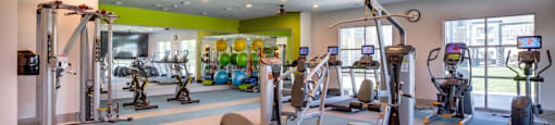 Georgetown Apartments for Rent - Williamson at the Overlook Fully Equipped Fitness Center with Large Windows, Ellipticals, Treadmill, and Various Cardio Equipment