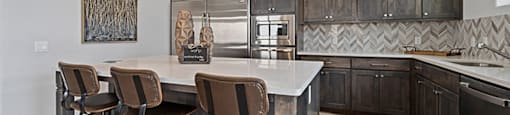 Apartments for Rent in Lewisville, TX - The Villas at Rockbrook - Kitchen with Granite Countertops, Kitchen Island, and Stainless-Steel Appliances.