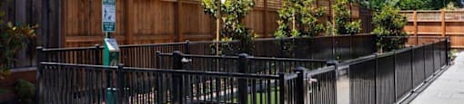 a park bench sitting in front of a fence