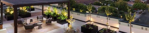 a roof top patio with furniture and a view of the city