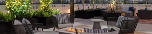 Apartments Santa Clara, CA - Santana Terrace - A Modern Outdoor Lounge Area Under a Pergola, Featuring Cozy Seating Around a Fire Pit.