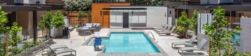 1-Bedroom Apartments in Santa Clara, CA - Santana Terrace - Swimming pool with Lounge Chairs, Beautiful Landscaping, and a Wooden Bench in Front