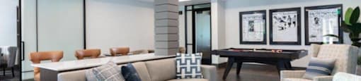Santa Clara, CA, Apartments - Santana Terrace - A Game Room with Contemporary Sofas and Armchairs, a Pool Table, and a Large Sliding Barn-Style Doors.