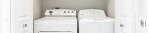In-unit washer and dryer with storage space at Sagewood at Westchase apartments in Houston, Texas.