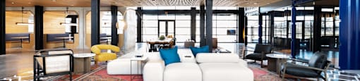 A large, open community lounge with a high ceiling and a mix of modern and industrial design elements.