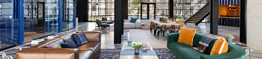 The community room insideThe Laura apartment complex in Houston, TX with long table and couches.