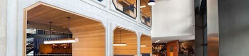 The Laura community lounge with wooden tables, benches, and a shuffleboard table..