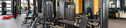 A gym with a variety of equipment including weights and machines.