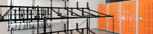 A gym with orange lockers and a black metal rack.