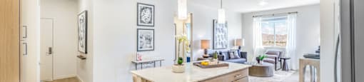 a kitchen with an island and a living room in the background