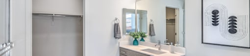 a bathroom with white walls and wood flooring