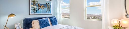 a bedroom with a bed and two windows