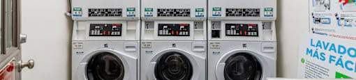 Hayward, CA Apartments - Paseo Gardens - Onsite Laundry Room with Stacked White Machines