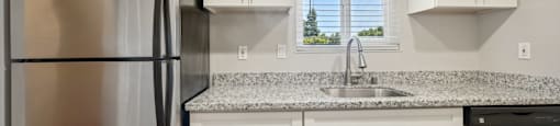 a kitchen with white cabinets and a stainless steel refrigerator