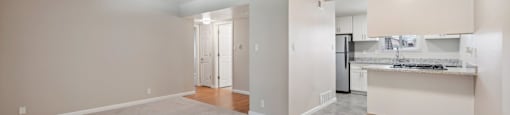 an empty living room and kitchen with a ceiling fan